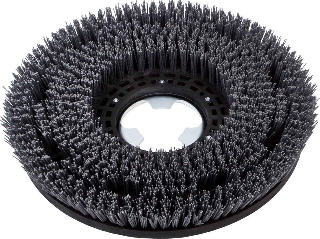 Brosse circulaire industrielle pour autolaveuse, à poils synthétiques gris foncé serrés en rangées concentriques, avec moyeu central en plastique noir et bague de montage métallique, photographiée sur fond blanc.